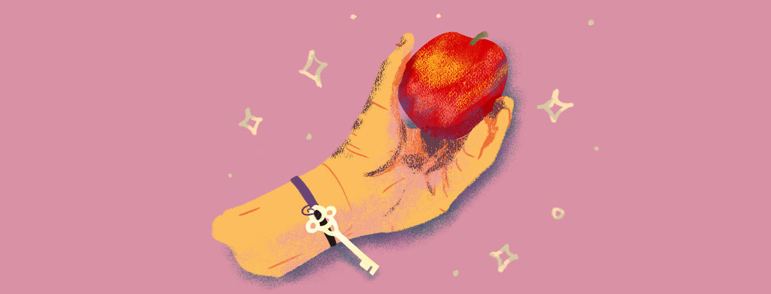 Hand with a key bracelet holding a healthy looking apple