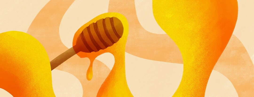 honey flowing off a wooden honey dipper
