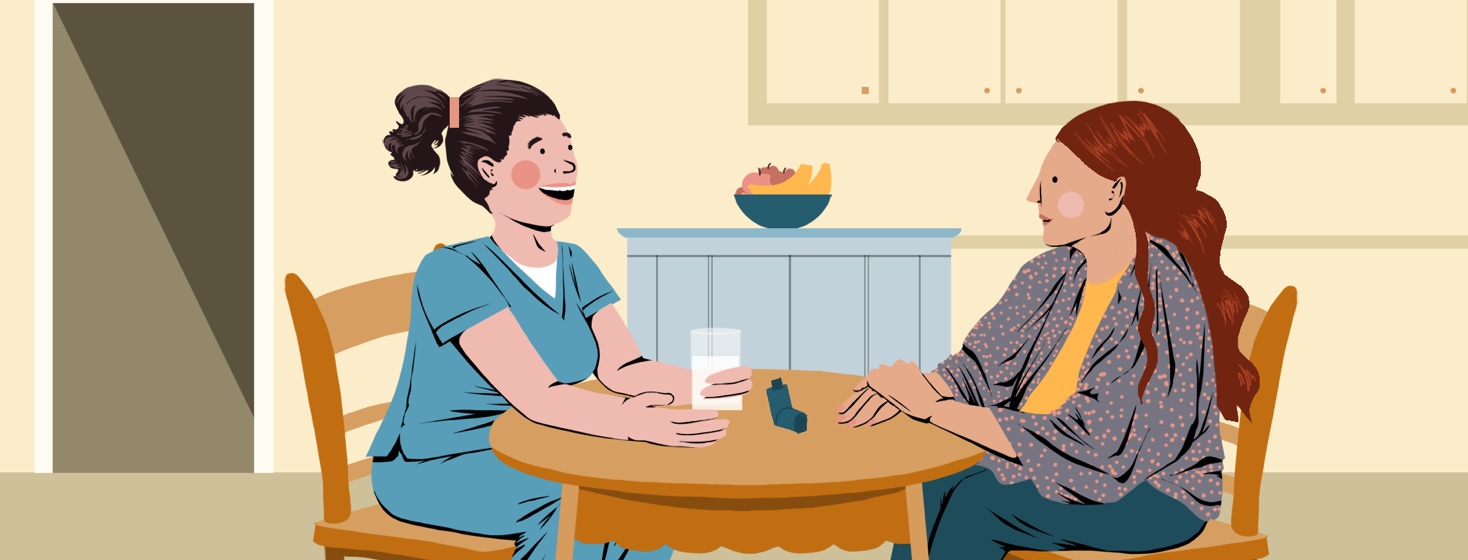 A woman sits at her kitchen table with a nurse, an inhaler on the table